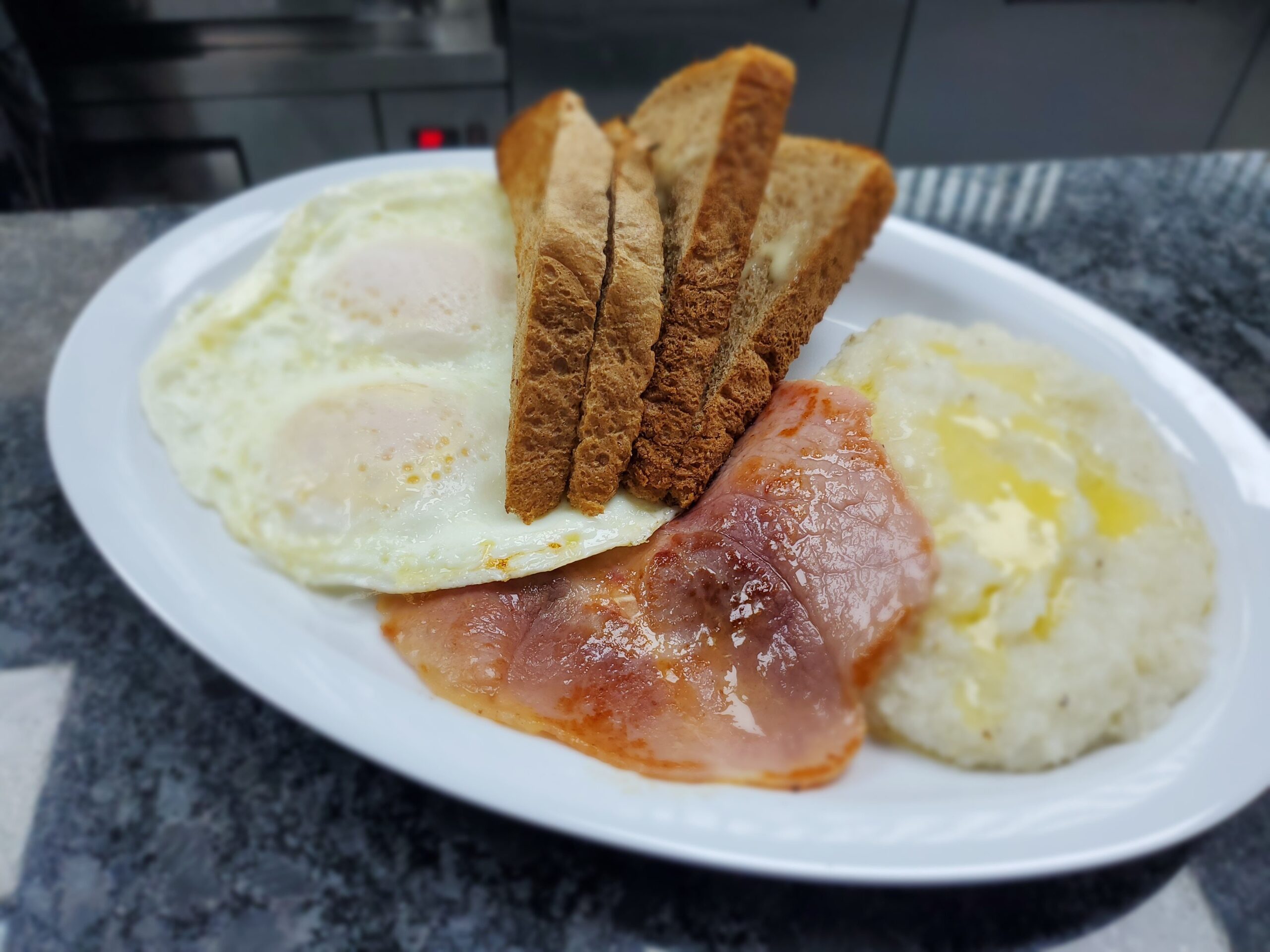 Fried Eggs, Grits, and Bacon or Ham with Toast